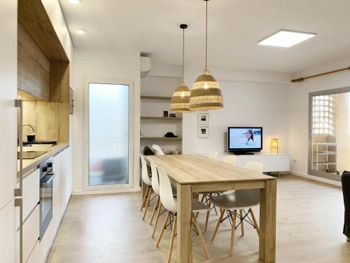 een keuken en eetkamer met een houten tafel en stoelen bij Apartamento de 3 habitaciones a 100 m de la playa del Arenal, Javea in Platja de l'Arenal