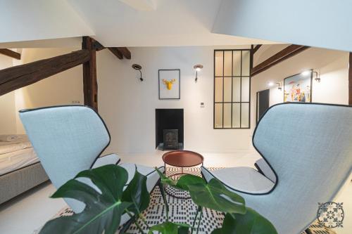 a living room with two chairs and a plant at Villa Chez les Amis - Adults only in Balatonszepezd