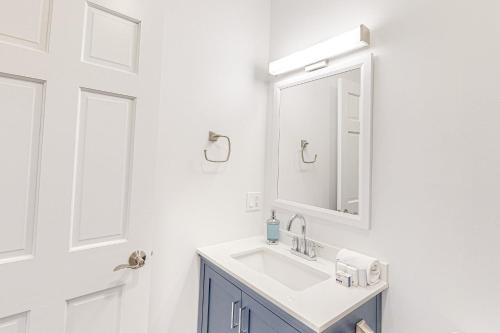 a white bathroom with a sink and a mirror at Whale's Tale in Boothbay Harbor
