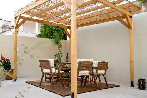 a wooden pergola with a table and chairs under it at Arokaria in Ierápetra