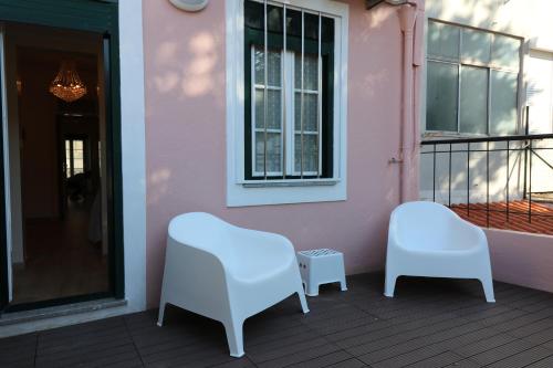 two white chairs and a window on a balcony at Discovery Apartment Estrela in Lisbon
