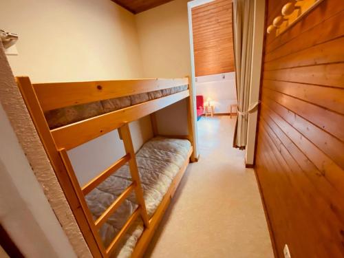 a bunk bed in a room with a wooden wall at Studio La Clusaz, 1 pièce, 4 personnes - FR-1-459-61 in La Clusaz