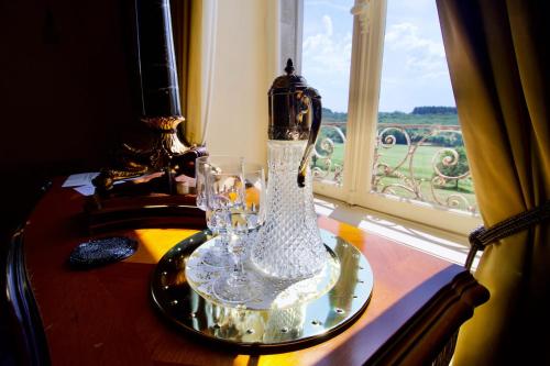 a glass vase sitting on a table next to a window at Chateau les Villettes in Saint-Just-le-Martel