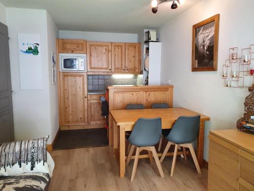 uma pequena cozinha com uma mesa de madeira e cadeiras em 2 pièces Valloire pied des pistes em Valloire