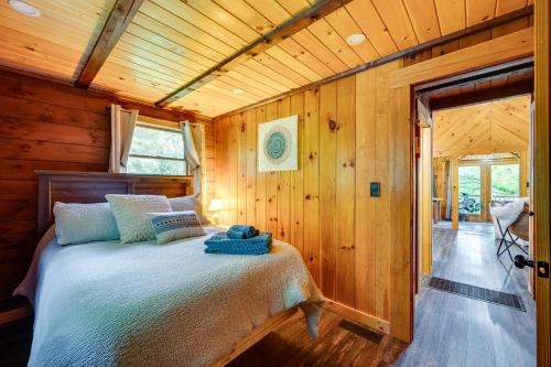 1 dormitorio con 1 cama en una cabaña de madera en North Haverhill Cabin with Fire Pit and Grill!, 