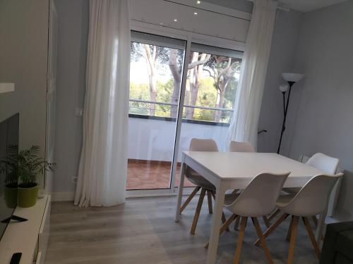 uma sala de jantar com uma mesa e cadeiras e uma janela em Vilar d'Aro Apartment em S'agaró