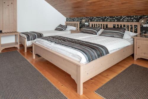 two beds in a bedroom with wooden floors at Guesthause Pr' Jozef in Bled