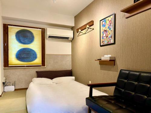 a hotel room with a bed and a chair at 上野浅草銀座近い 山手線御徒町駅3分 アメ横3分 上野駅10分 上野広小路駅3分 湯島駅2分 2-4人 レトロ和風畳寝室 in Tokyo