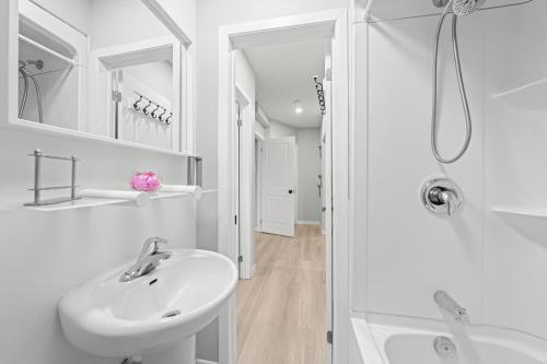 a white bathroom with a sink and a shower at Close to mall with private toilet, Free Wi-Fi and Parking in Toronto