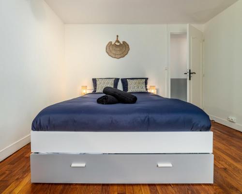 una camera da letto con un grande letto bianco con lenzuola blu di Blue sky cottage near CDG airport a Le Mesnil-Amelot