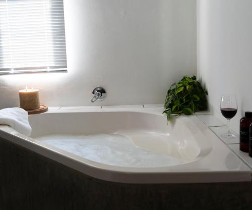 bañera blanca con vela y copa de vino en Little Karoo, en Somerset East