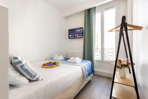 ein weißes Schlafzimmer mit einem Bett und einem Fenster in der Unterkunft Résidence Beaugrenelle - Tour Eiffel 1 in Paris