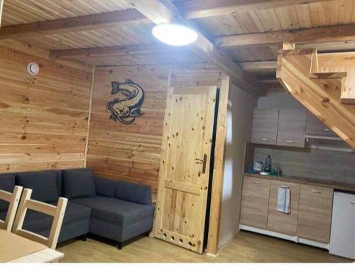 - un salon avec un canapé bleu et un mur en bois dans l'établissement Domki nad morzem u Sumy, à Sztutowo