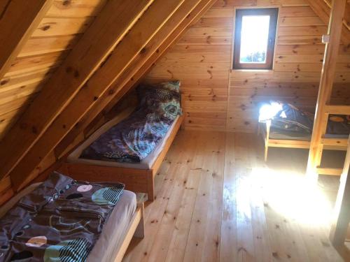 an attic room with two beds and a window at Domki nad morzem u Sumy in Sztutowo