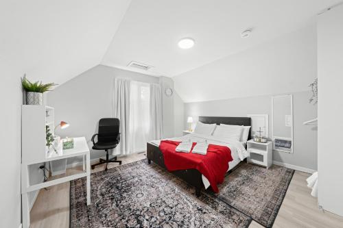 biała sypialnia z czerwonym łóżkiem i krzesłem w obiekcie Close to Centrepoint Mall, Work space, Kitchen with essentials, Free parking w mieście Toronto