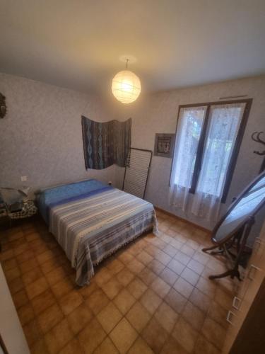 une chambre avec un lit et une chaise dedans dans l'établissement Belle maison de campagne, à Chaffaut-Lagremuse