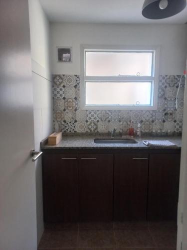 een keuken met een wastafel en een raam bij Dos22 Apartment in Mendoza