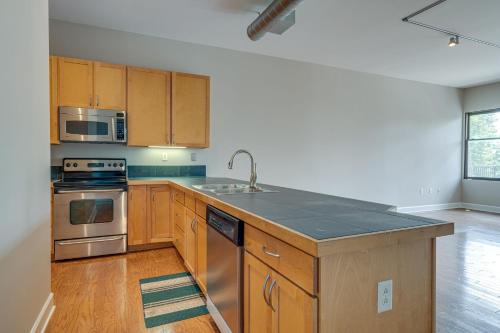 a kitchen with wooden cabinets and a stainless steel appliance at Historic Edgefield 2bd 2ba Loft in Nashville