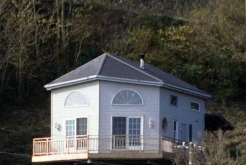 a white house with a bird sitting on top of it at Patagonia Home in Shimoda