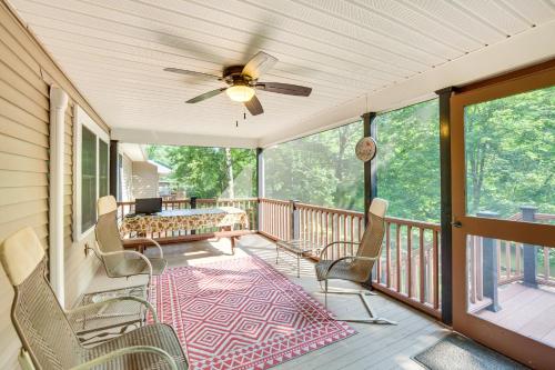 a screened porch with chairs and a ceiling fan at Quaint Elysburg Cottage Walk to Knoebels Resort! in Paxinos