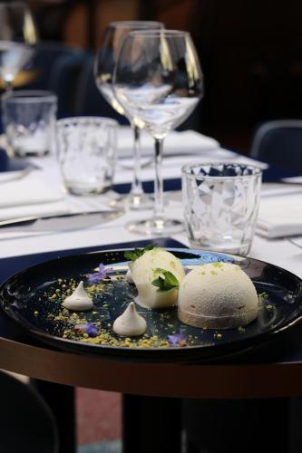 a plate of food on a table with a wine glass at L'Eautel Toulon Centre Port in Toulon