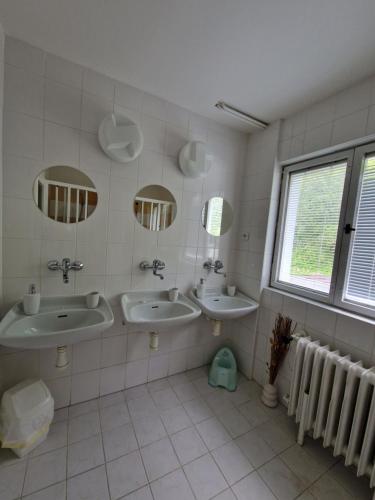 a bathroom with two sinks and two mirrors at Pension Piana in Pec pod Sněžkou