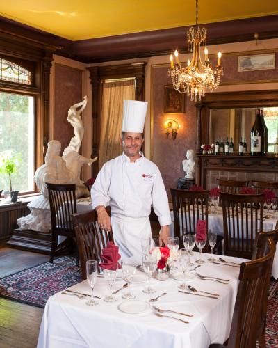 un chef de pie en una mesa en un restaurante en Upjohn, en Kalamazoo