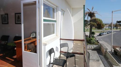 a balcony with chairs and a window and a street at Peniche Housing | Tree The Company in Peniche