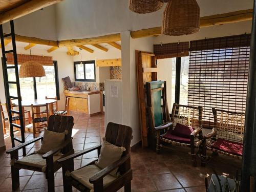 sala de estar con sillas, mesa y cocina en Sonko en Tafí del Valle