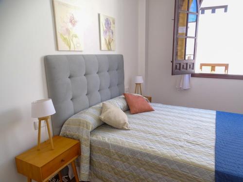 a bedroom with a bed with a large headboard at Apartamento con vistas a la Giralda. in Seville