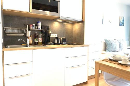 a kitchen with white cabinets and a sink at M11 Le vieux MassyRER600mOrly20 minNetflixNeuf in Massy
