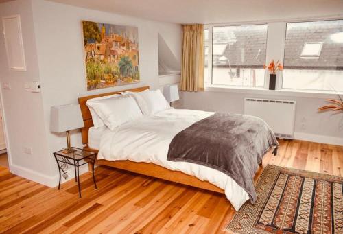 a bedroom with a large bed and a rug at Paris Rooftop Studio at The Residence, Bantry in Bantry