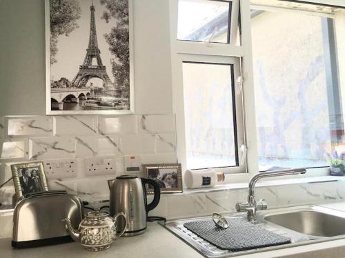a kitchen counter with a sink and a tower in a window at Paris Rooftop Studio at The Residence, Bantry in Bantry