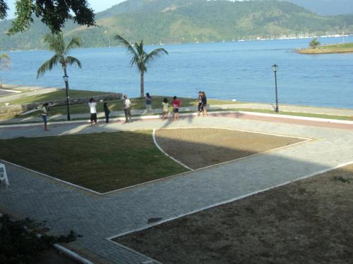 a group of people playing basketball on a court by the water at Pousada do Imperador in Paraty