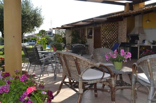 a patio area with tables, chairs and umbrellas at Villa Adriana B&B in Comiso