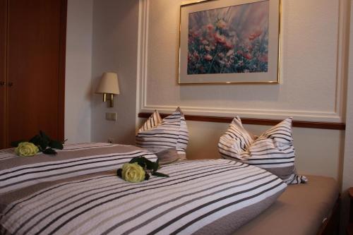 two beds in a hotel room with flowers on them at Ristorante Pizzeria Pension Taormina in Roßhaupten