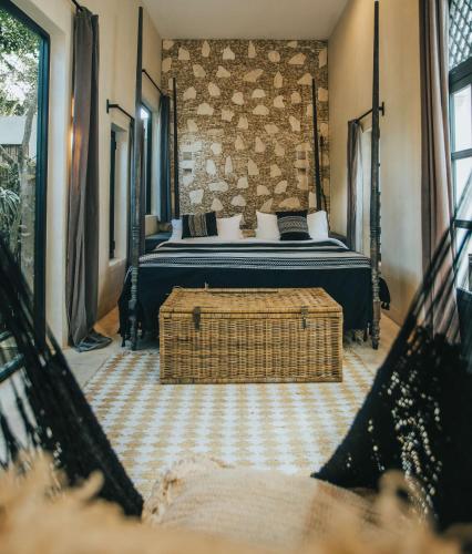 a bedroom with a bed and a basket on the floor at Yum Kaax Boutique Villa in Tulum