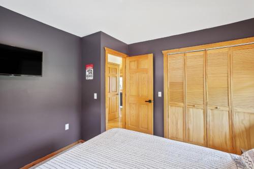 a bedroom with a bed and a flat screen tv at Crystal Lake Vacation Rental, 3 Mi to Betsie River in Beulah