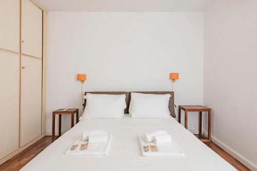 Vatican View Apartment - Zen Real Estate في روما: غرفة نوم بسرير ابيض مع طاولتين