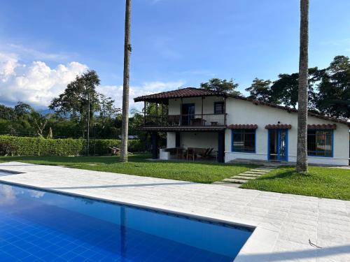una casa e una piscina di fronte a una casa di Casa El Tesorito a La Tebaida
