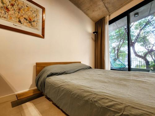 een slaapkamer met een bed en een groot raam bij G&G Apartments - Palermo Cozy Studio in Buenos Aires