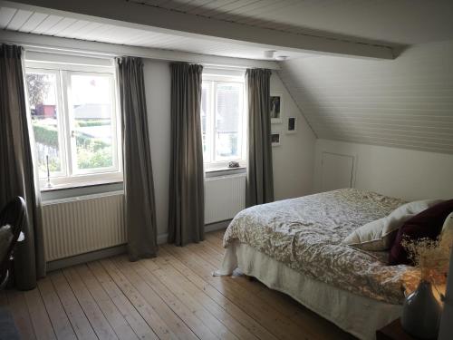 Lindebjerggårds Bed and Breakfast في Melby: غرفة نوم بسرير ونوافذ