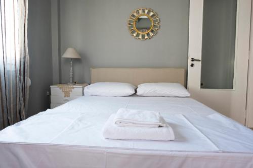 a white bed with a white towel on it at House 8 in Ermoupoli