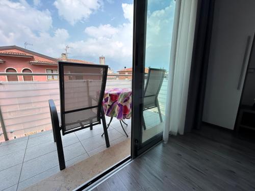 a room with a balcony with a table and a view at Gardesana Active Apartments in Malcesine