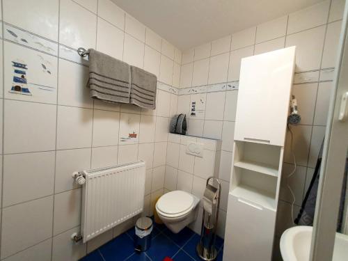 a white bathroom with a toilet and a sink at Ferienhaus Regina im Bohnental in Lebach