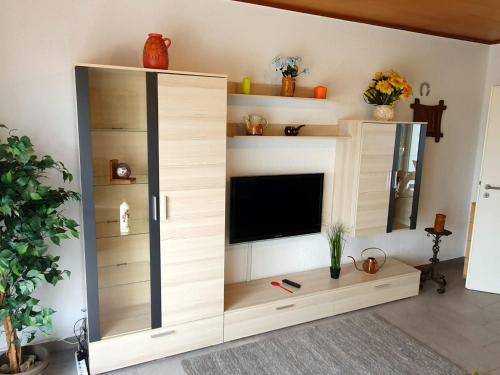 a large wooden entertainment center with a flat screen tv at Ferienhaus Regina im Bohnental in Lebach