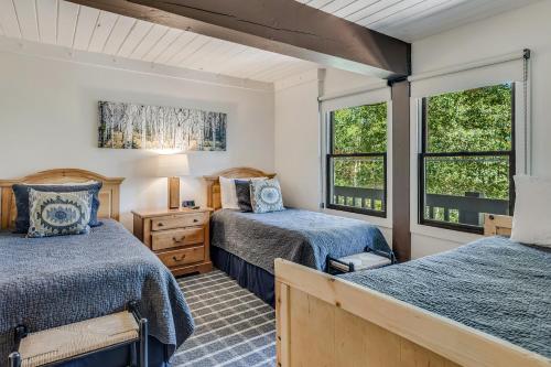 two beds in a room with two windows at Interlude Condominiums 2-Bedroom Unit 204 in Snowmass Village