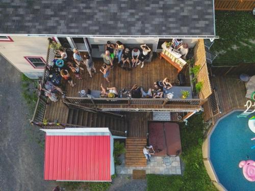 a group of people sitting on the deck of a house at Auberge Mandala in Saint Mathieu Du Parc