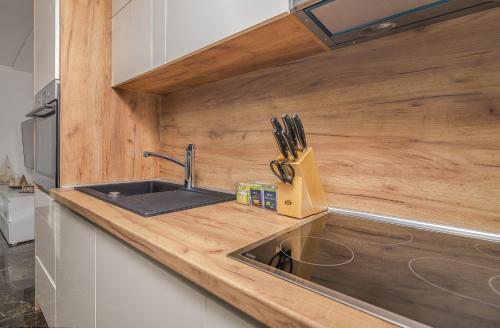 a kitchen with a sink and a wooden counter top at Apartment Aurora Island Krk Malinska in Sveti Anton