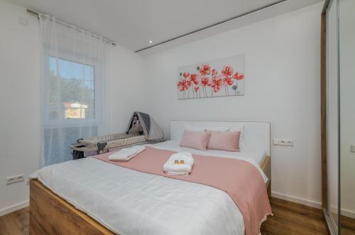 a bedroom with a large bed with pink and white sheets at Apartment Aurora Island Krk Malinska in Sveti Anton